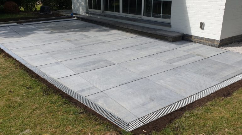 Création d'une terrasse en dalles de pierre bleue de 80x80cm par Greenrod, votre partenaire en entretien de jardins, élagage, construction d'abris de jardin etc.